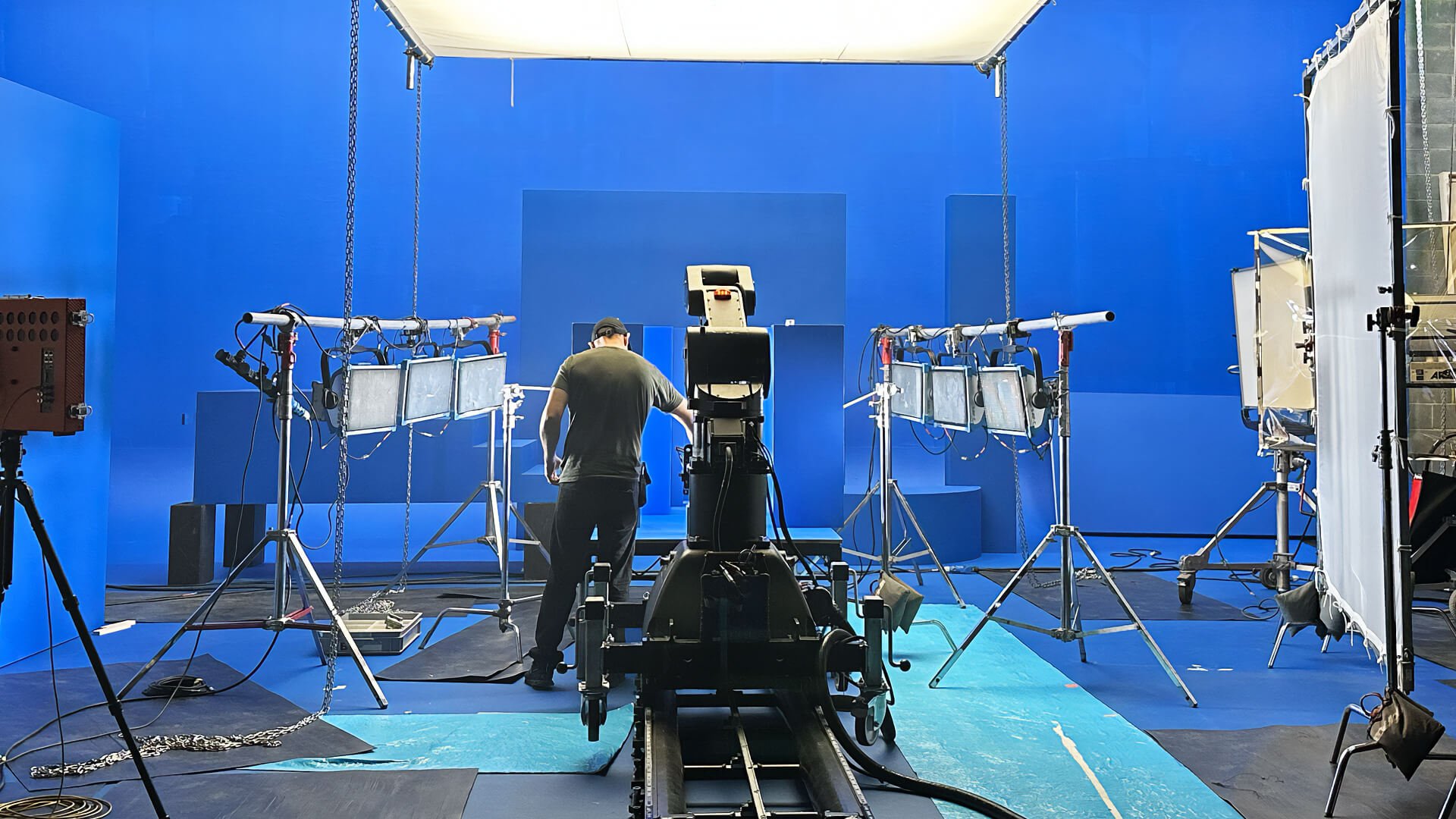 person on blue screen commercial set with l.e.d. panel lights